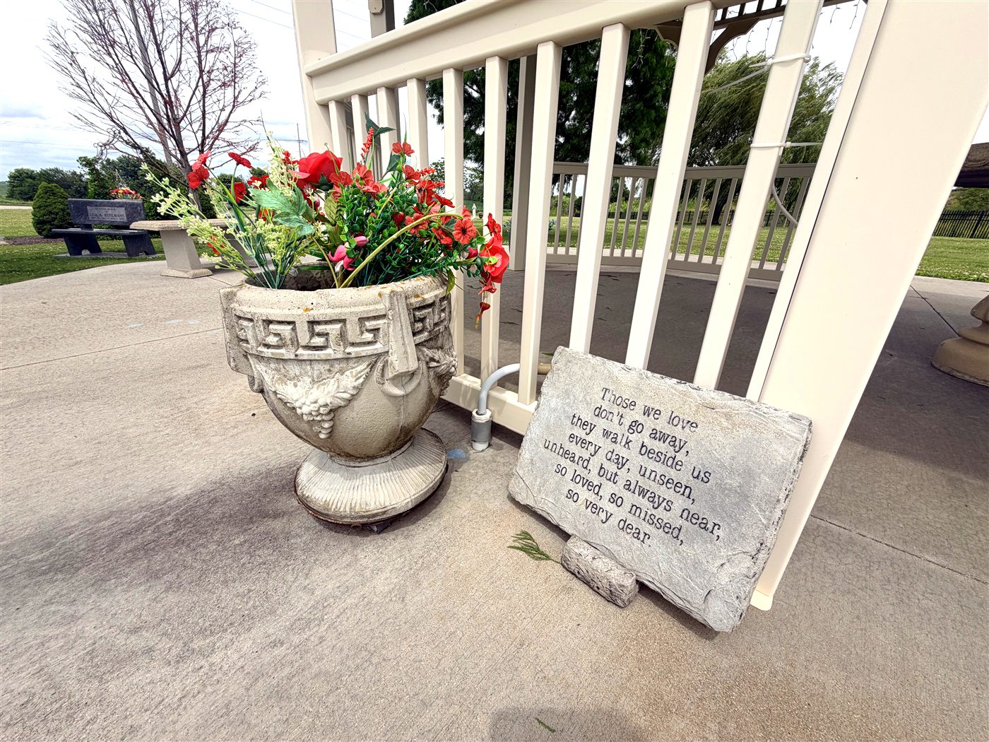 A memorial urn of flowers and a remembrance stone at Forever Home Cemetery